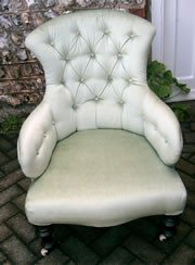 A late Victorian buttoned back chair with turned legs