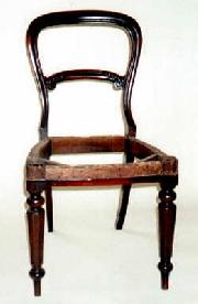 An early Victorian Balloon back dining chair, in Mahogany with a carved rail.